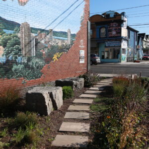 A wall mural and a garden at a street orner