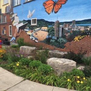 A beautiful city mural with a garden in front