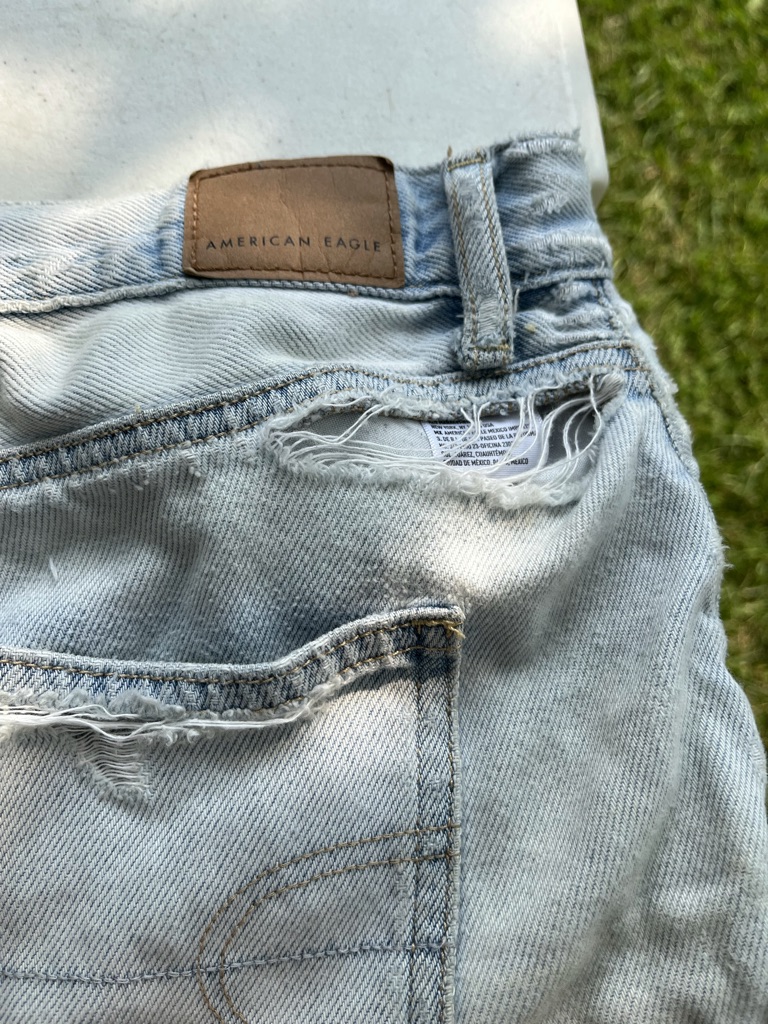 [ID: Close up of tear on denim shorts along waistband] 