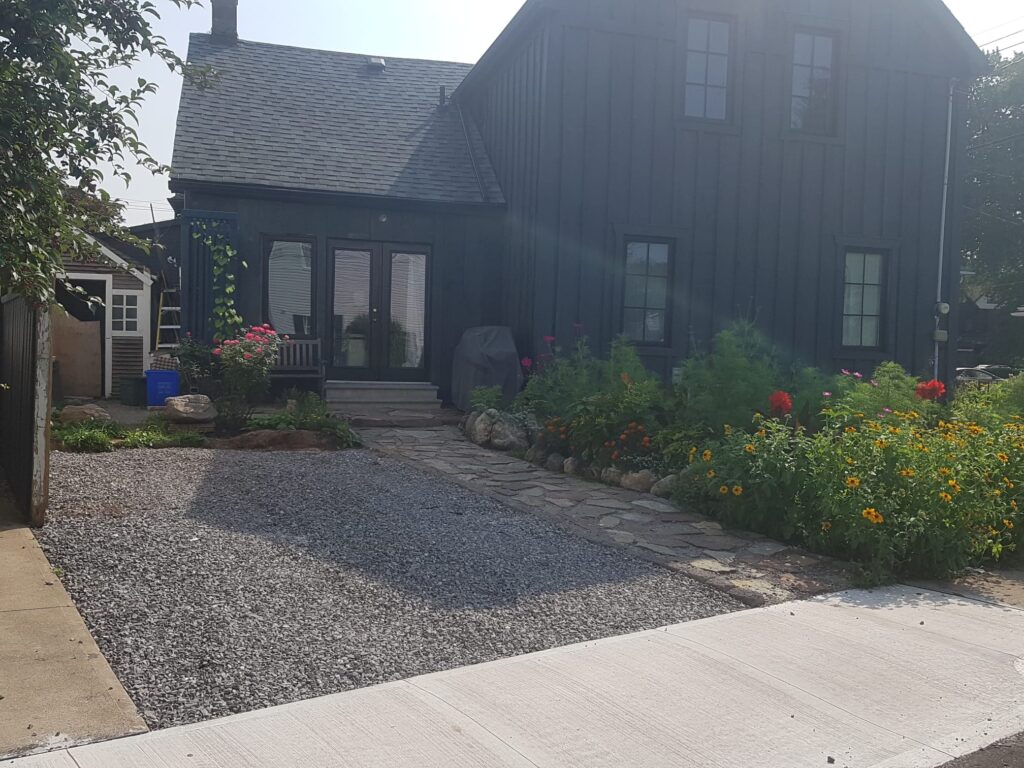 A house with a permeable gravel driveway, flagstone path and large garden